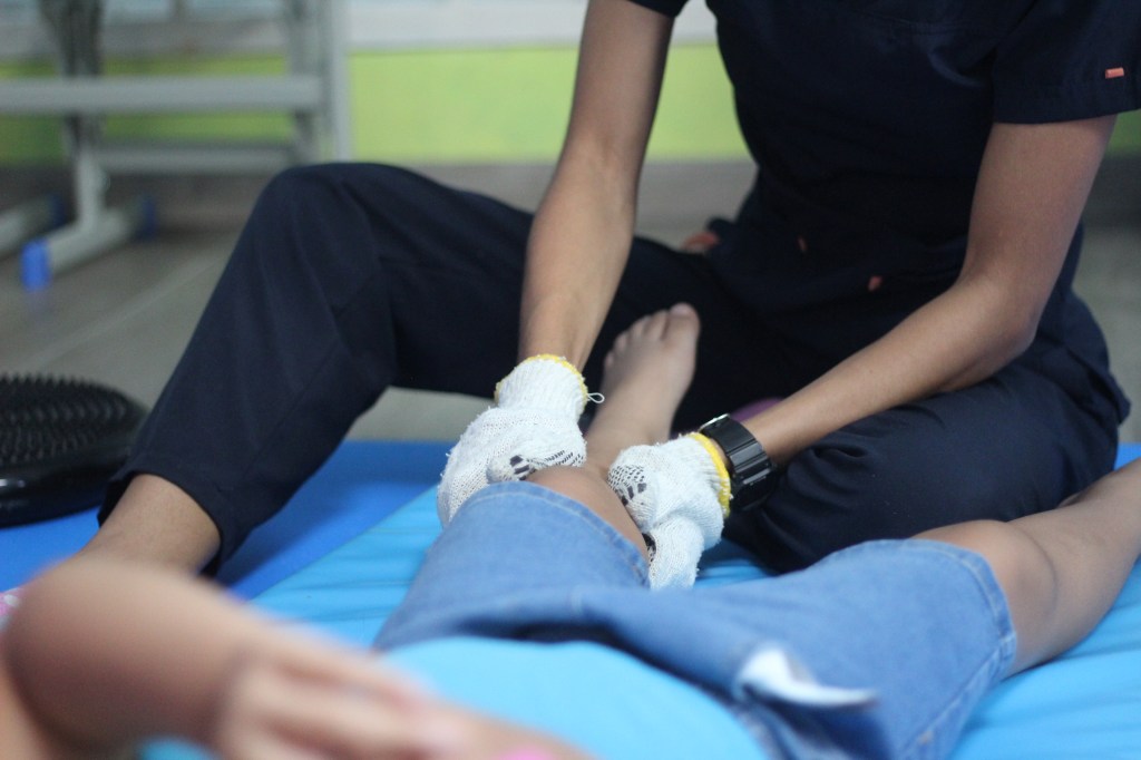 Terapeuta aplicando masaje de integración sensorial a un niño en Integra Vidas