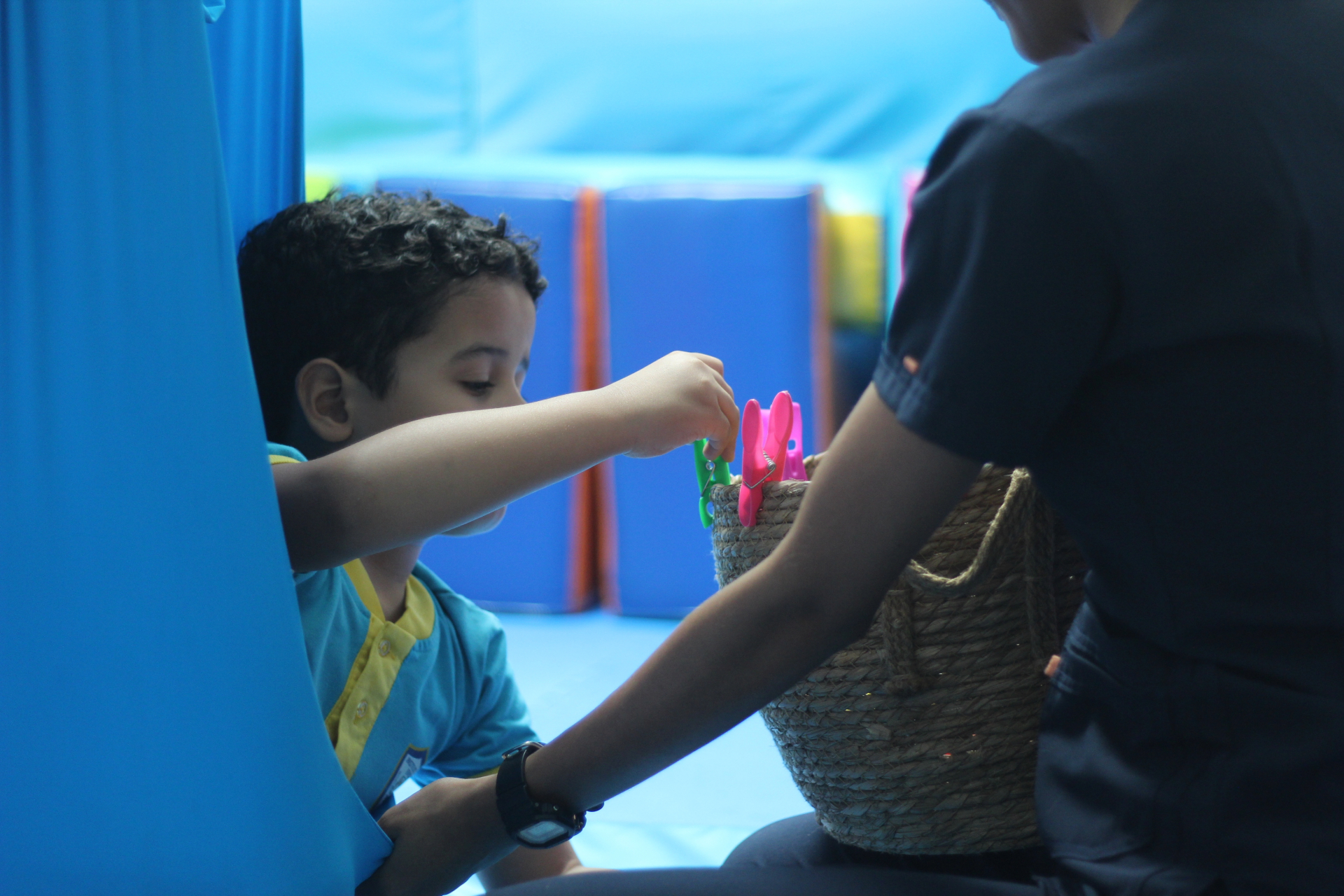 Niño en terapia de integración sensorial usando hamaca de licra