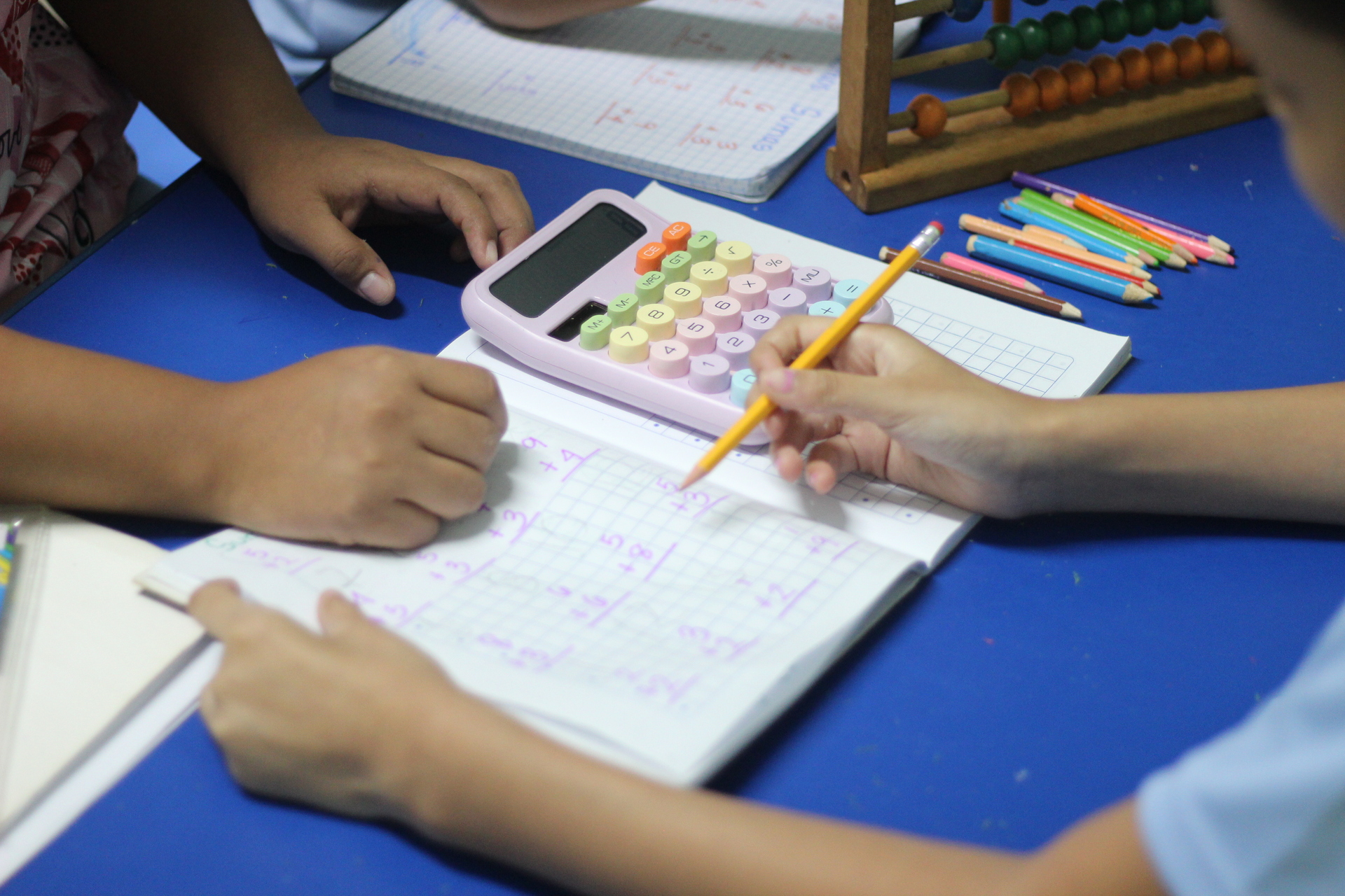 Niño con discalculia realizando sumas con materiales educativos, acompañado de su maestra de educación especial en Integra Vidas