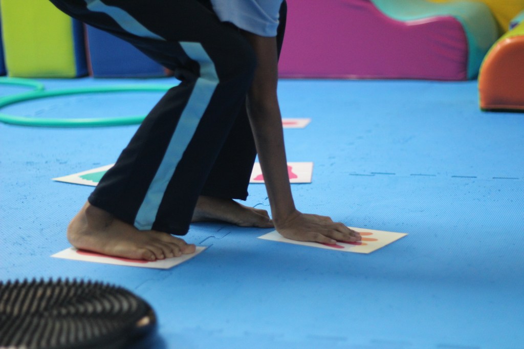 Niño realizando un circuito de integración sensorial para estimular planeamiento motor, lateralidad y coordinación.